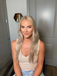 a blonde woman sitting on a chair in a room