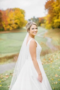 a bride in a wedding dress standing in a field