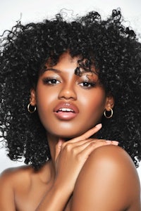 a black woman with curly hair posing for a photo