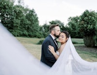 a bride and groom embracing under a veil